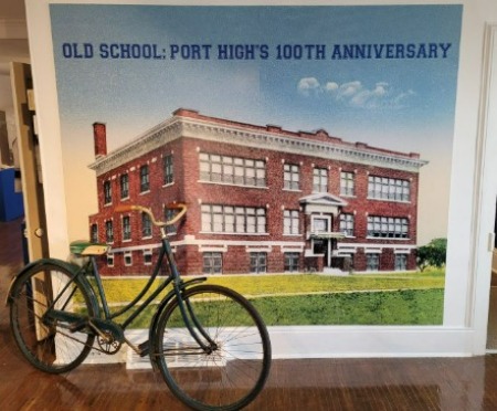 photo of old bike in front of photo of school